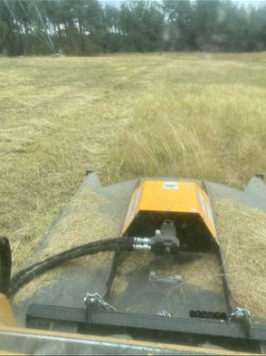 action shot of large mower in a vast field from LawnScapes