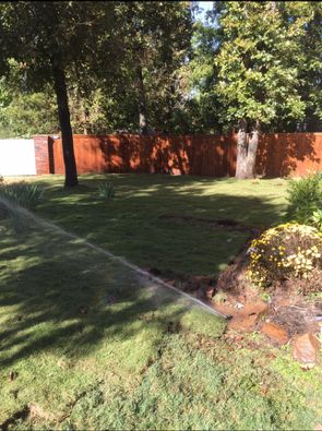 lawn care by LawnScapes with wooden privacy fence